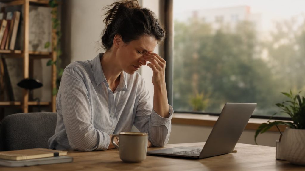 Person showing daytime tiredness and difficulty concentrating at work, a common insomnia symptom